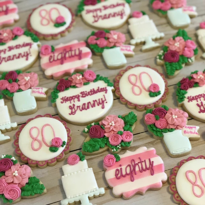 cookies in the shape of flowers and cakes, 80th birthday ideas, decorated in white purple and pink