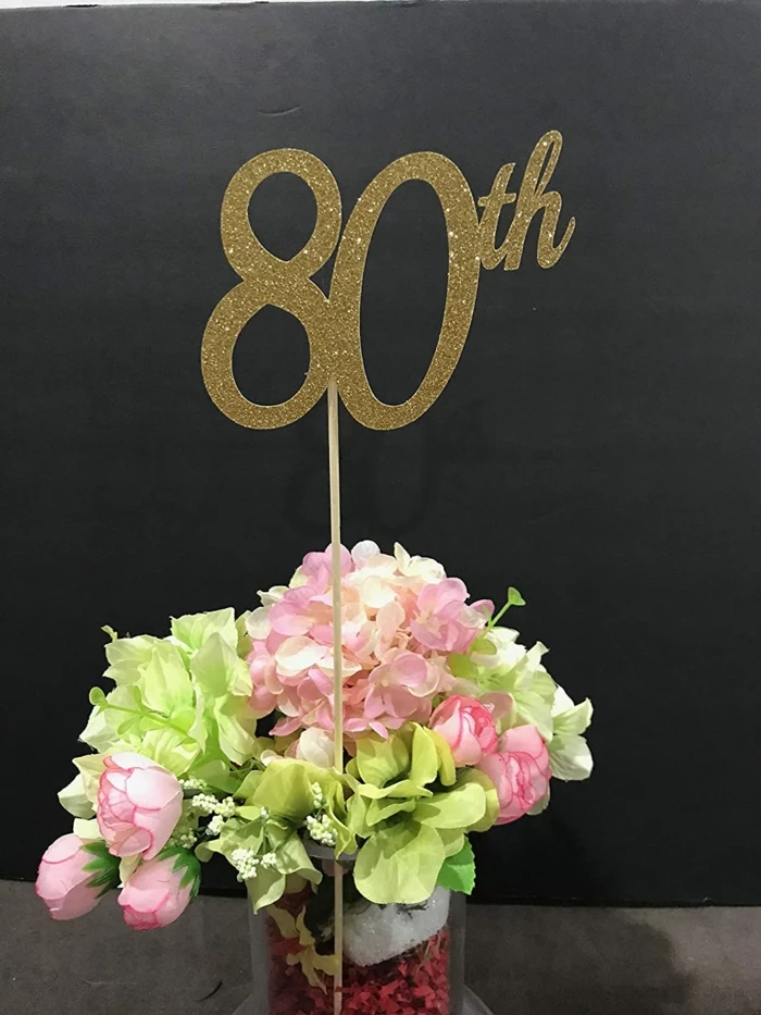 flower arrangement with pink and green flowers, 80th birthday decorations, gold glitter 80th sign in the middle