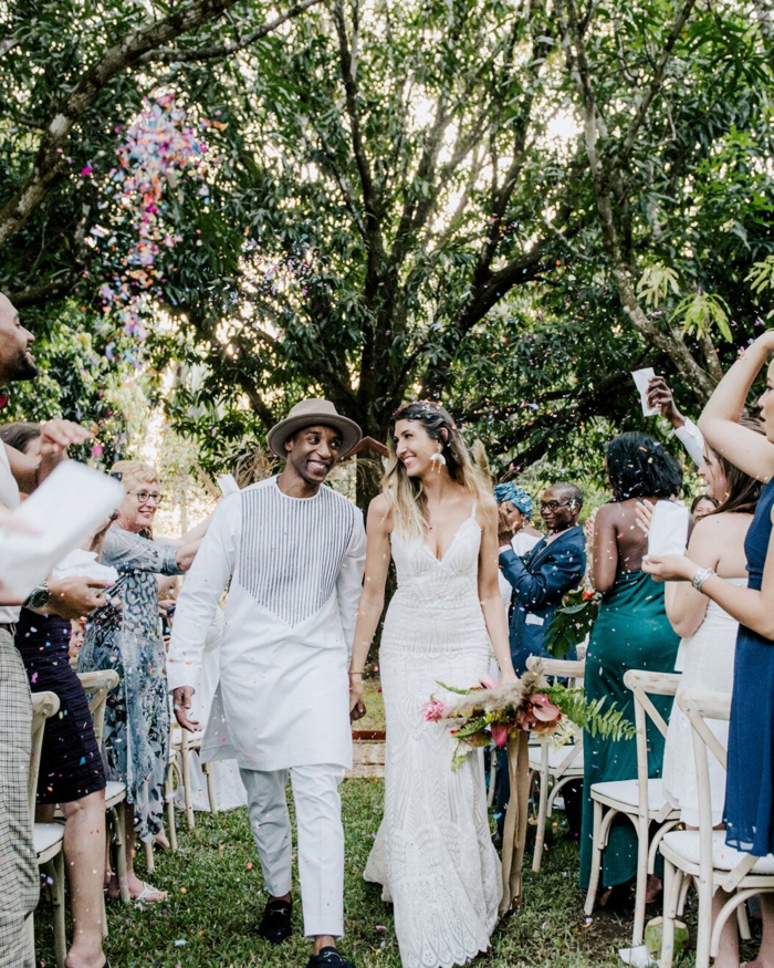 bride and groom walking down the aisle, wedding entrance songs, garden wedding, people throwing confetti in the air