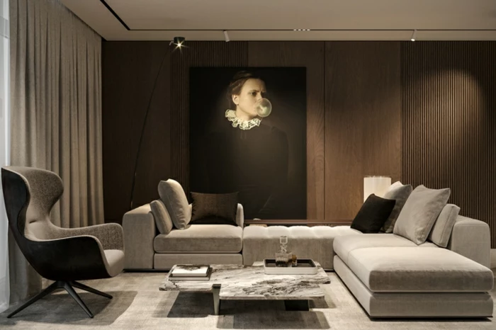 white corner sofa, grey armchair, modern living room furniture, wooden accent wall with artwork on it