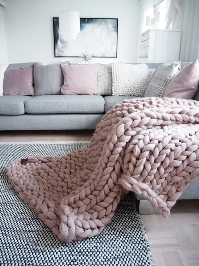large light pink merino wool blanket, spread on a grey corner sofa, traditional anniversary gifts