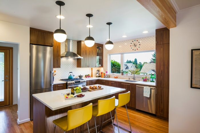 wooden cabinets with white countertops, mid century kitchen island, mustard yellow bar stools