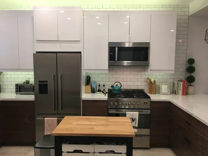 white subway tiles backsplash, mid century kitchen island, dark wooden cabinets with white countertops