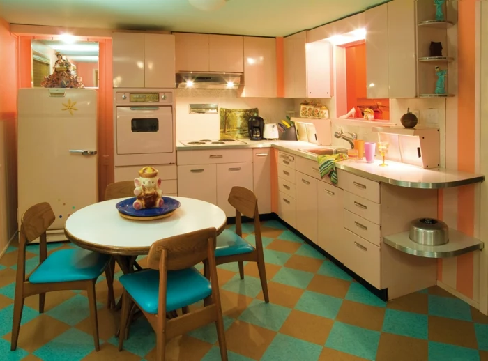 blue and orange riles on the floor, white cabinets, mid century kitchen island, blue chairs around white table