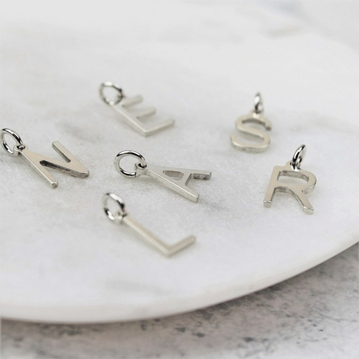 silver letters, 10th anniversary gift, necklace charms, placed on white surface