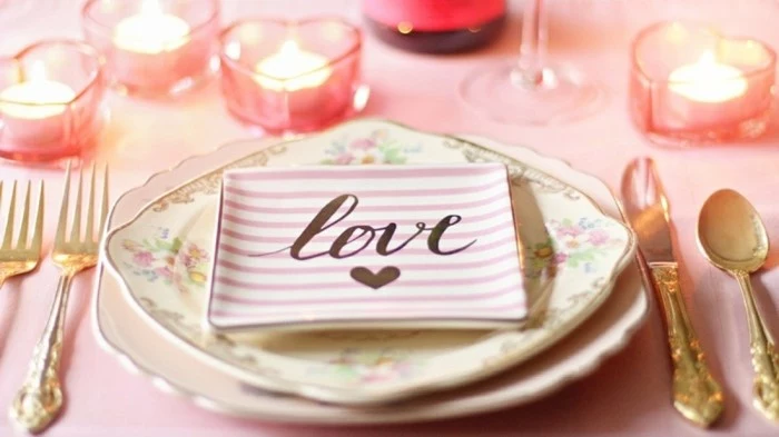 table setting in light pink, small plate with the word love written on it, wedding anniversary gifts