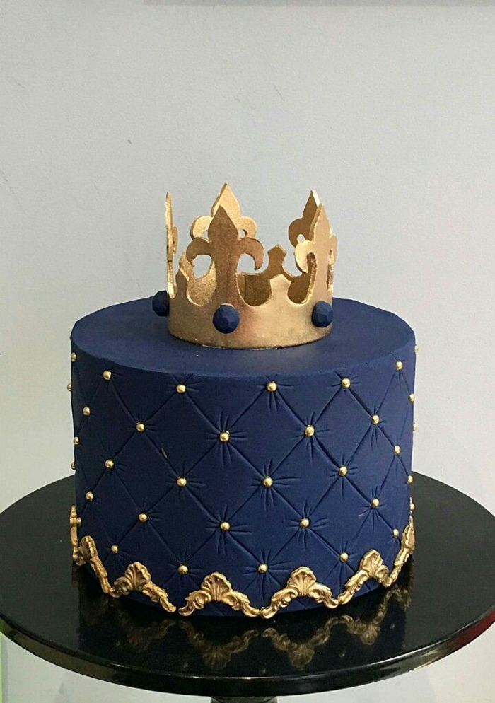 one tier cake, covered with blue fondant, gold crown on top made of fondant, surprise party ideas, black tray