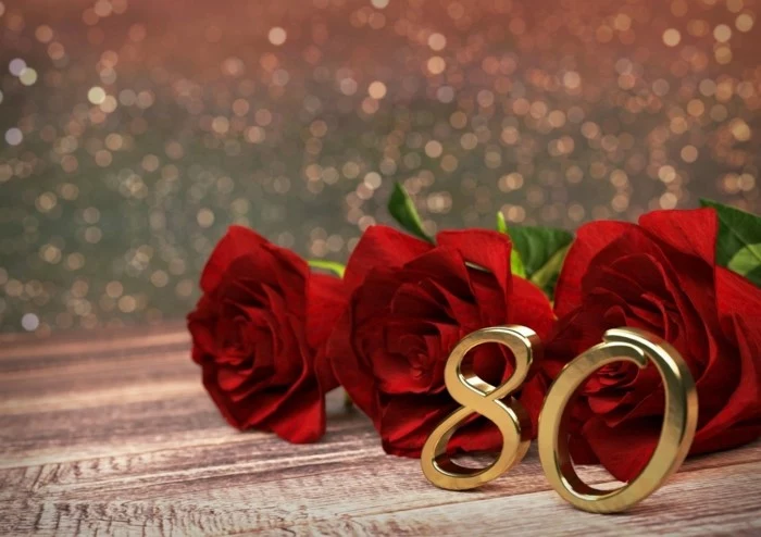 80th birthday color, three red roses, metal number eighty, placed in front of them
