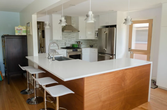 wooden kitchen island, white cabinets with white countertops, mid century modern floor tile, light grey tiles backsplash