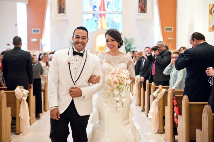 bride holding a roses bouquet, bride walking down the aisle songs, photo from inside the chapel