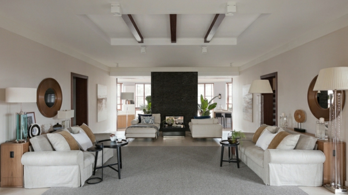 white sofas, small black coffee tables, contemporary living room furniture, wooden floor with grey carpet