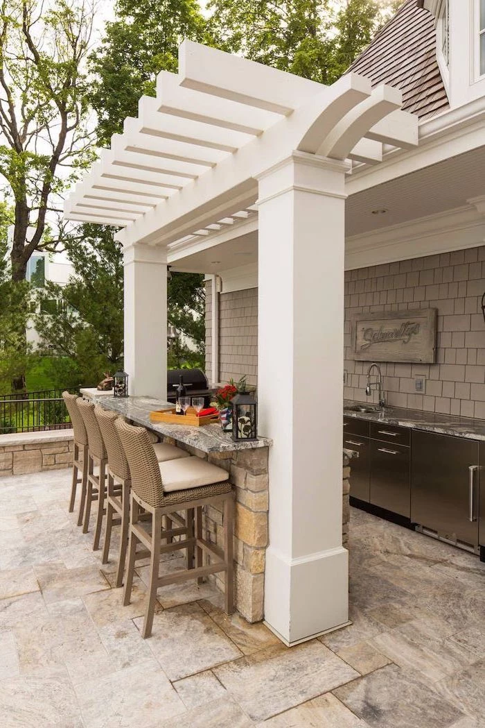 backyard kitchen bar made of stones with marble countertops tall bar stools kitchen cabinets and sink with marble countertop