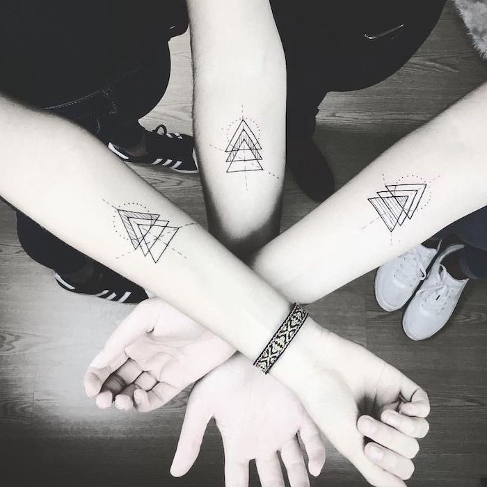 black and white photo brother and sister matching tattoos geometric tattoos of three siblings three triangles