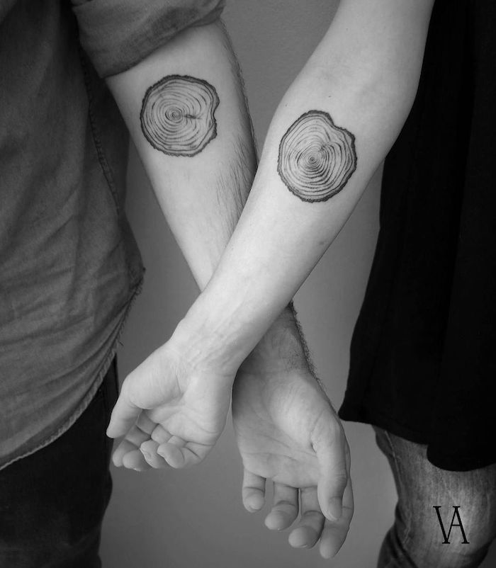 black and white photo of matching forearm tattoos brother sister matching tattoos sliced logs