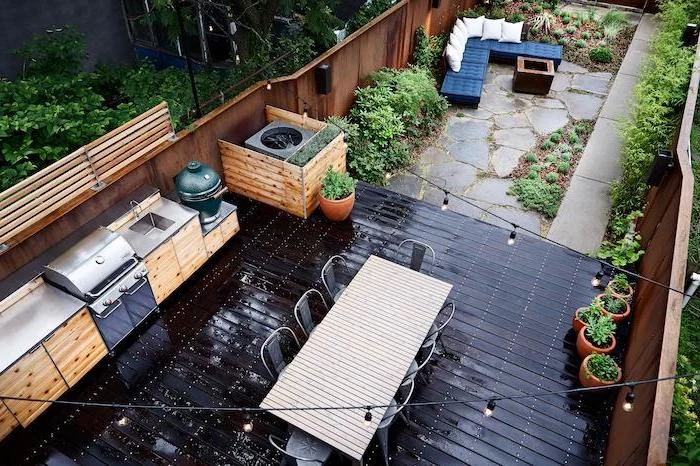 black floor with wooden cabinets and metal countertop covered outdoor kitchen long dining table and black chairs