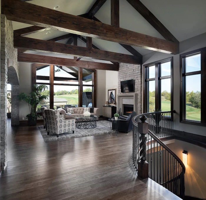 wooden floor, exposed wooden beams on white ceiling, farmhouse living room, furniture set in front of a fireplace