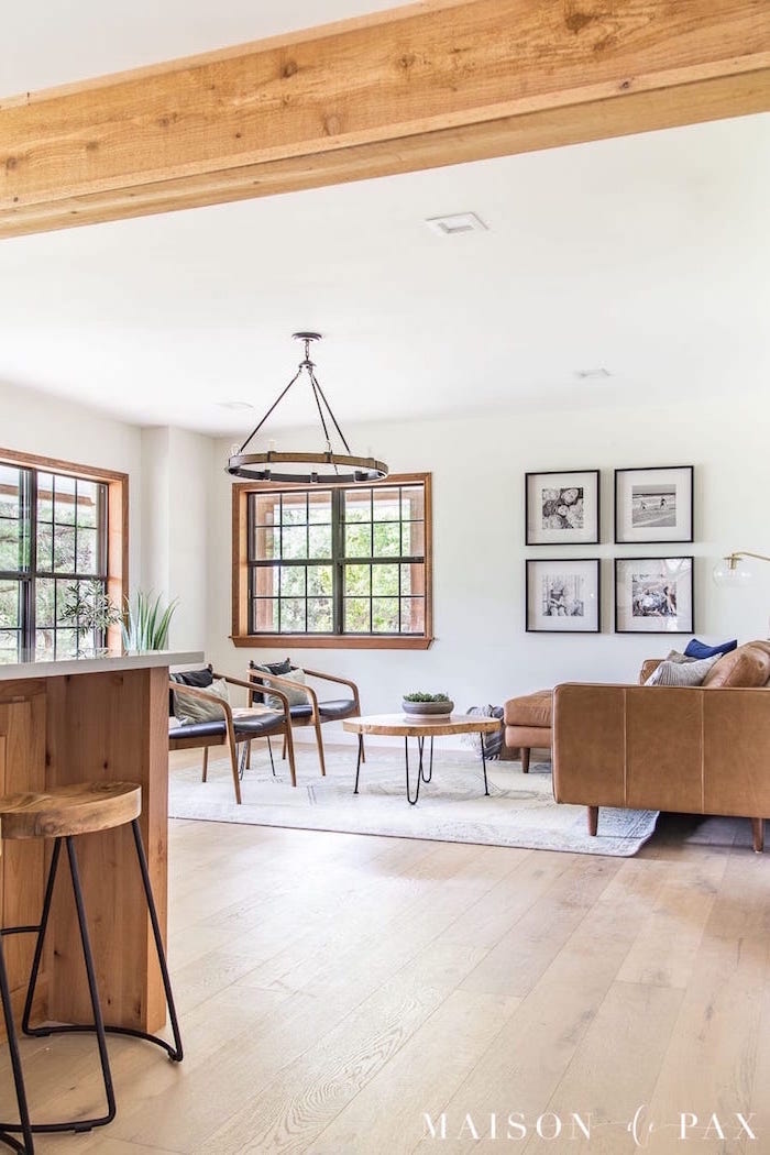 black leather armchairs, small round wooden coffee table, farmhouse living room, brown velvet corner sofa, carpet on wooden floor