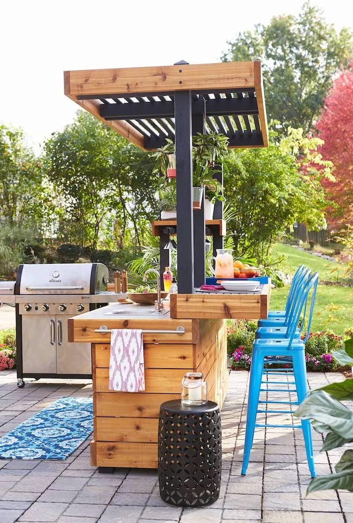 blue metal bar stools l shaped outdoor kitchen wooden kitchen island with sink metal grill reclaimed setts on the floor