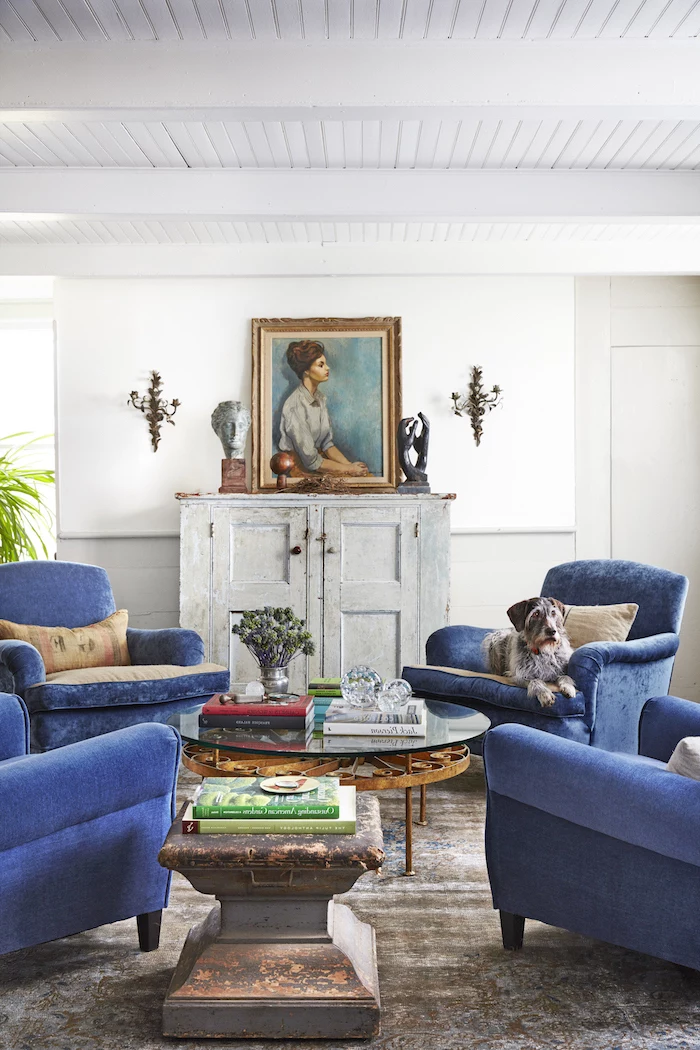 four blue velvet armchairs, glass and metal table, farmhouse decor, refurbished cabinet with framed painting on top