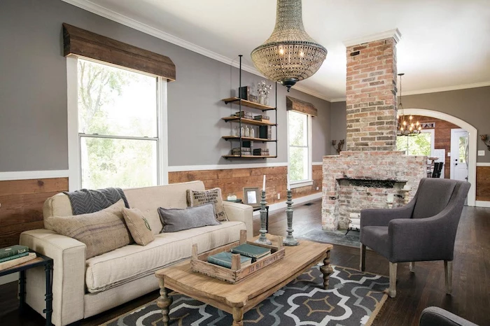 white sofa and grey armchair, wooden coffee table, modern farmhouse decor, placed in front of a fireplace, made of bricks