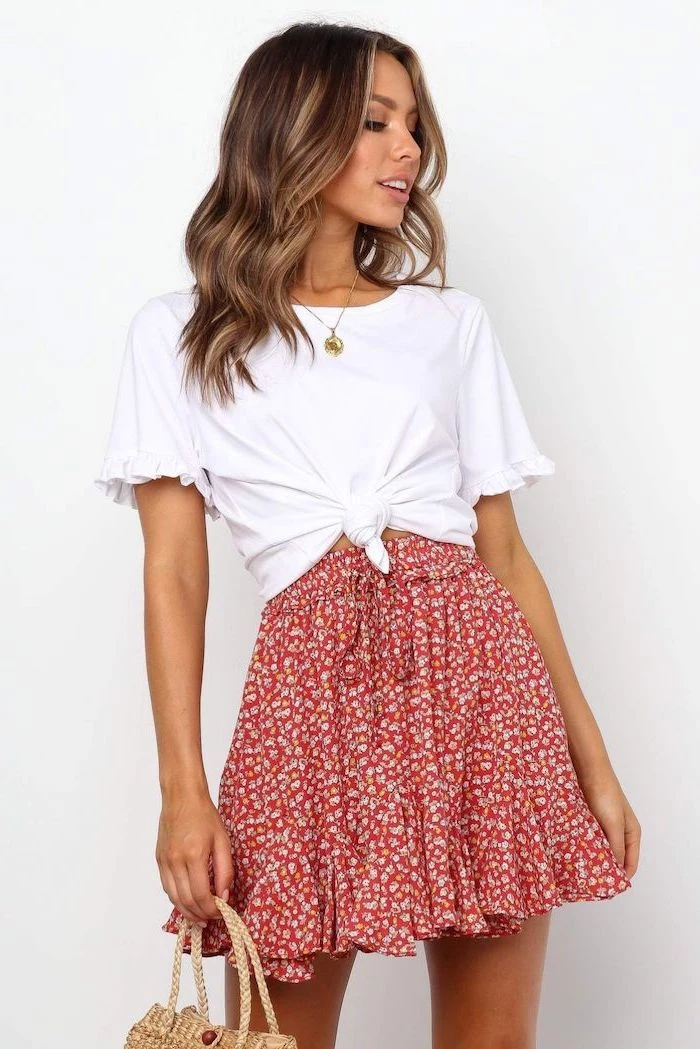 brunette woman wearing floral skirt white t shirt tied at the waist cute outfit ideas white background