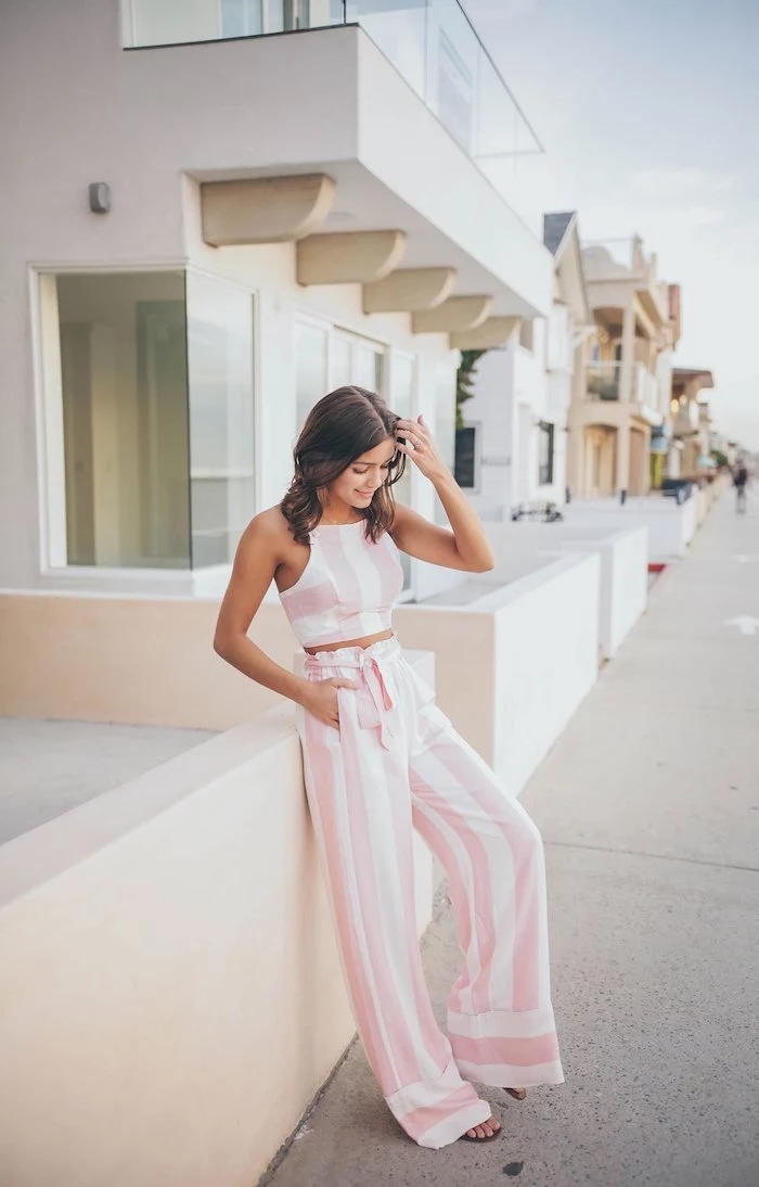 brunette woman wearing pink and white striped wide fit trousers and crop top cute casual summer outfits black sandals