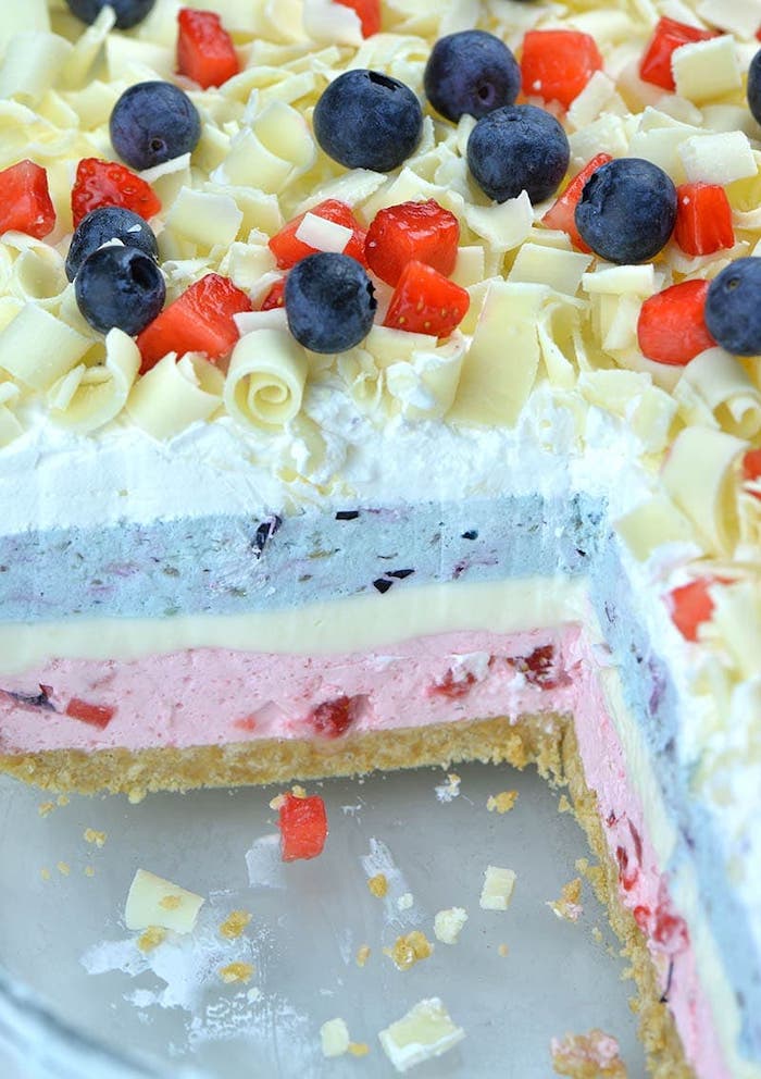 cake with missing slice with white pink and blue layers no bake dessert recipes blueberries strawberries and white chocolate on top