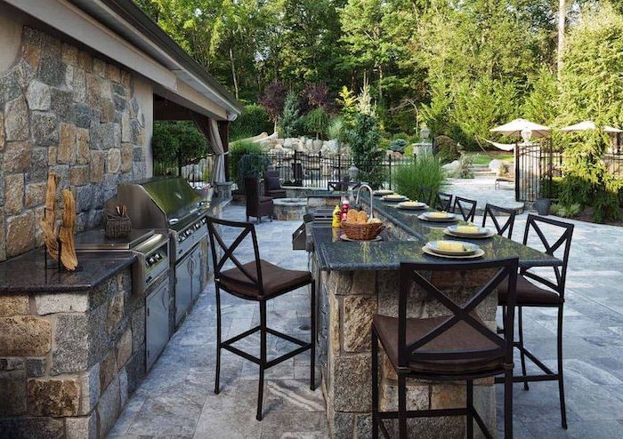 covered outdoor kitchen kitchen island with black granite countertop made of stone tall bar stoold tiled floor