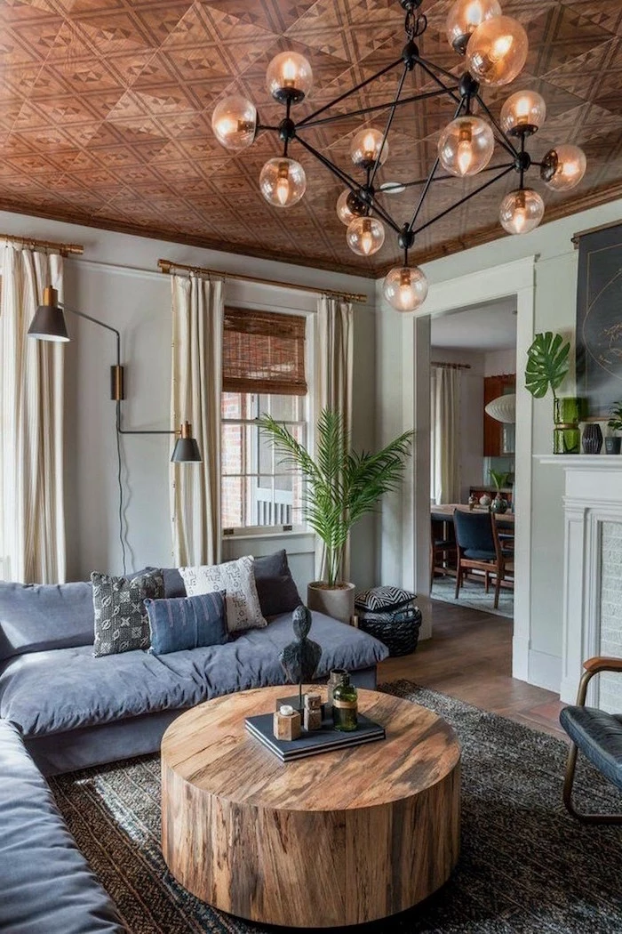round wooden coffee table, rustic home decor, dark grey corner sofa, dark grey carpet on wooden floor