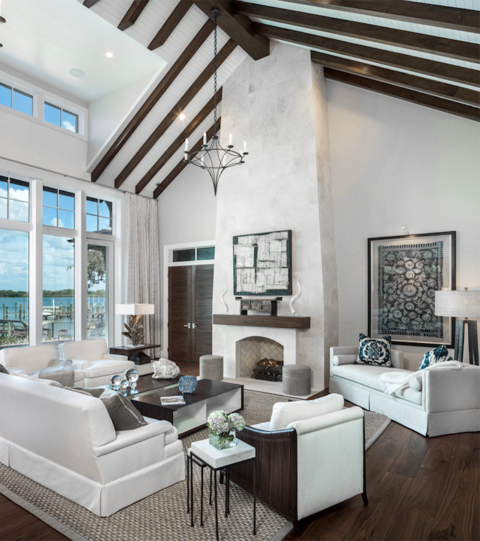 exposed wooden beams on white ceiling, farmhouse living room decor, white furniture set, placed in front of a fireplace