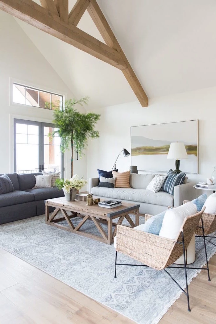 white walls, exposed wooden beams on white ceiling, farmhouse living room decor, grey and white sofas, wooden coffee table