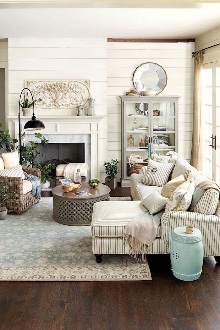 white furniture set, placed in front of a fireplace, modern farmhouse living room, round wooden coffee table, white carpet on wooden floor