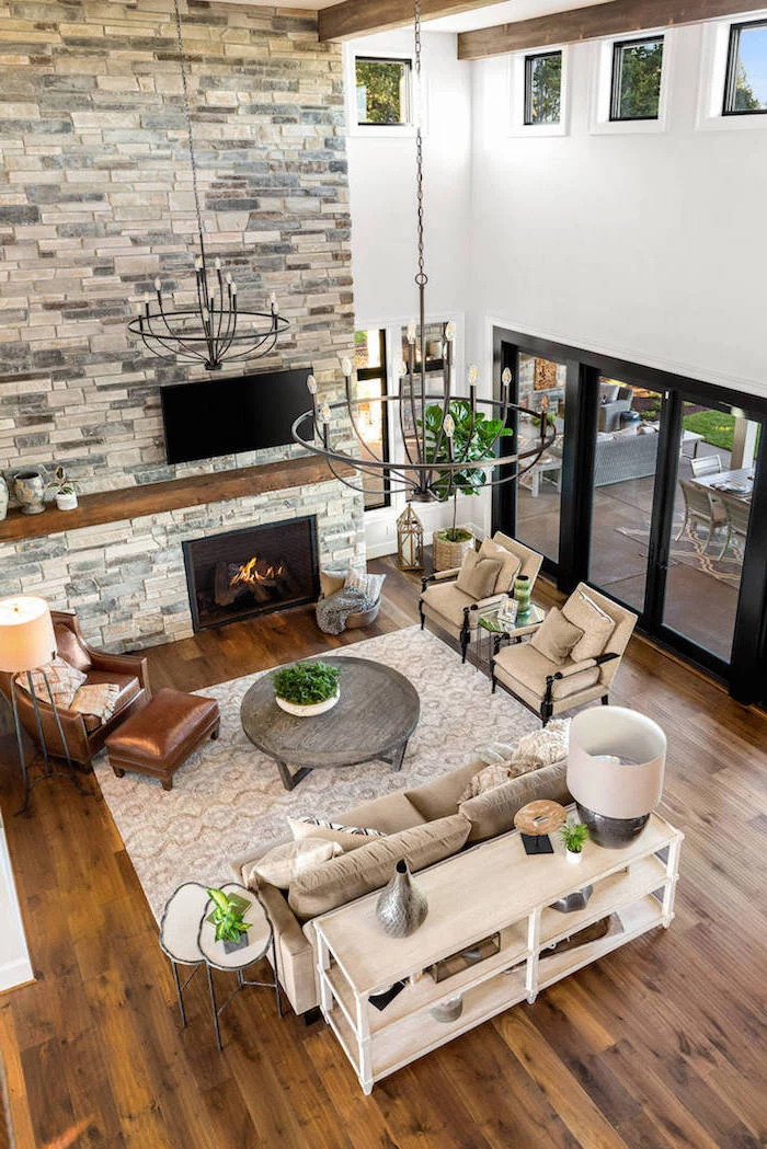 stone wall fireplace, brown leather armchair, farmhouse living room ideas, white furniture set, wooden floor