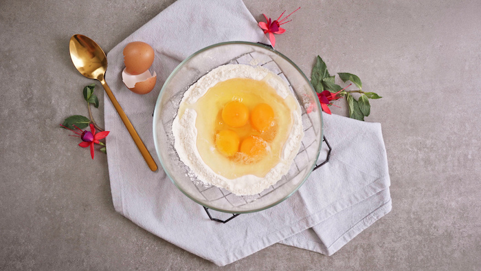 flour and eggs placed inside glass bowl placed on white table cloth summer desserts for parties