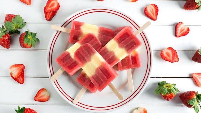 frozen popsicles arranged on white plate placed on white wooden surfaces strawberries scattered around it no bake desserts