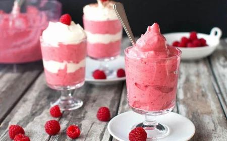fruit mousse made with raspberries summer desserts inside glasses on white plates with spoons