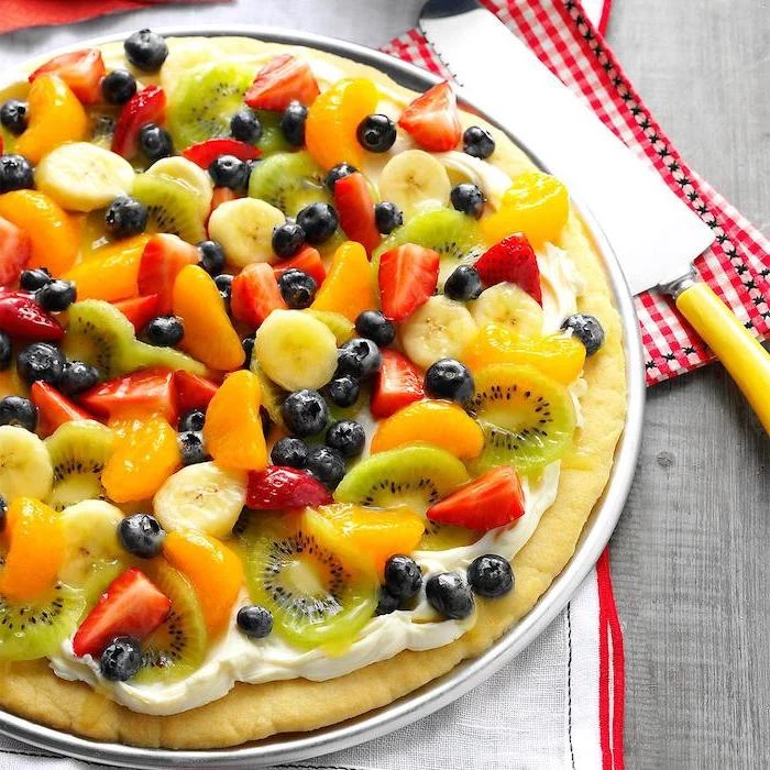 fruit pizza with oranges strawberries kiwi blueberries on top easy summer desserts placed on white plate