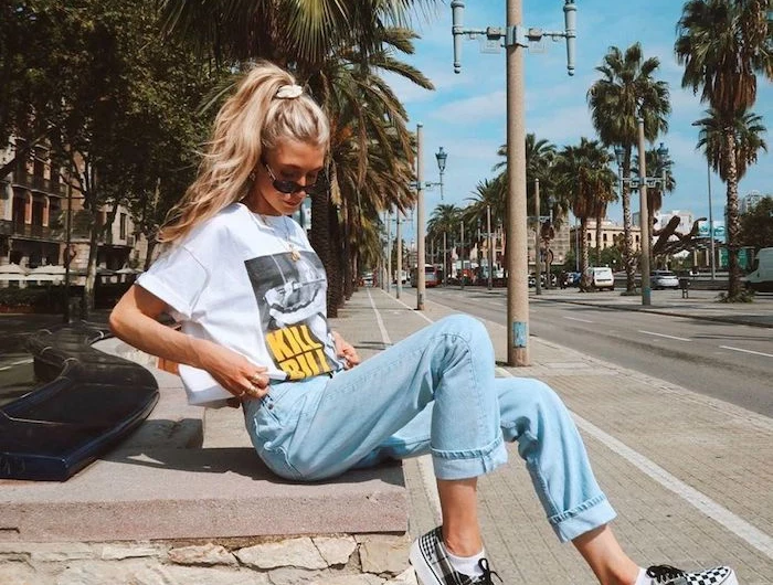 girl with long blonde wavy hair in ponytail wearing white kill bill t shirt cute summer shirts washed jeans vans sneakers