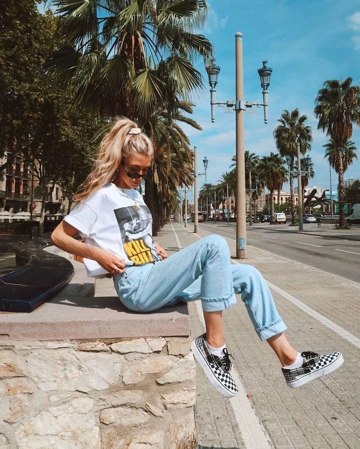 girl with long blonde wavy hair in ponytail wearing white kill bill t shirt cute summer shirts washed jeans vans sneakers