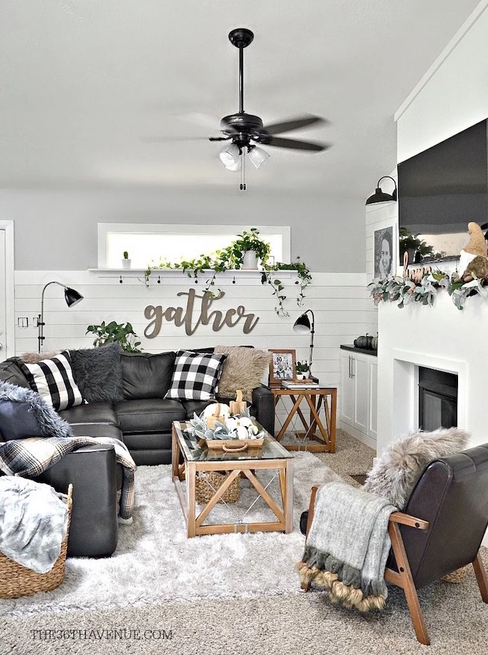 black leather corner sofa and armchair, black and white throw pillows, rustic farmhouse decor, placed in front of a fireplace