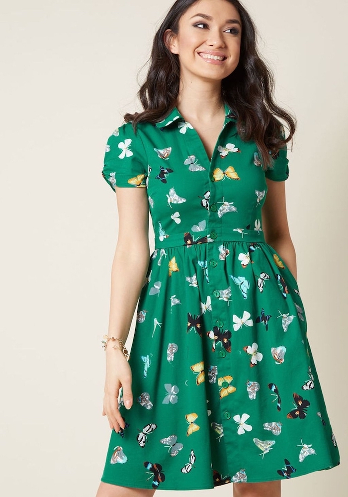 green dress with colorful butterflies print cute summer shirts worn by woman with medium length black wavy hair