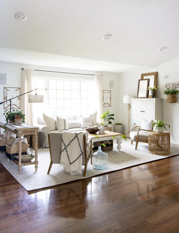 white carpet on wooden floor, rustic farmhouse decor, white sofa with grey armchairs, wooden coffee table