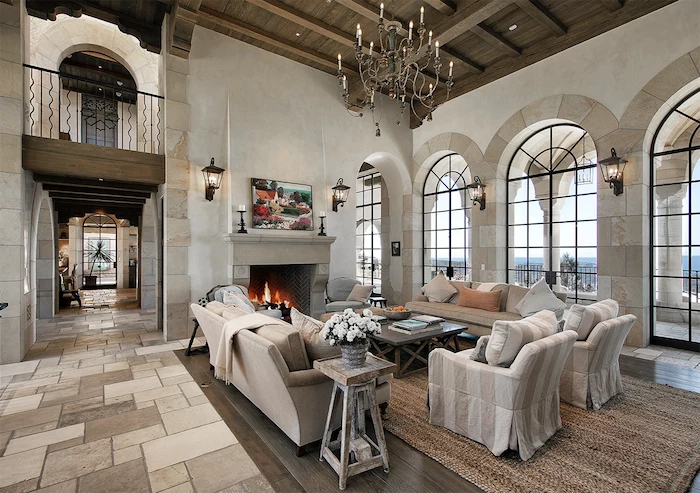 tall wooden ceiling, farmhouse style homes, white and grey furniture set, placed in front of a fireplace, tiled floor