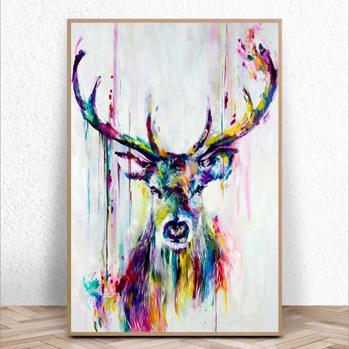 large deer, painted in different colors, painted on white background, watercolor techniques, framed and leaning on white wall