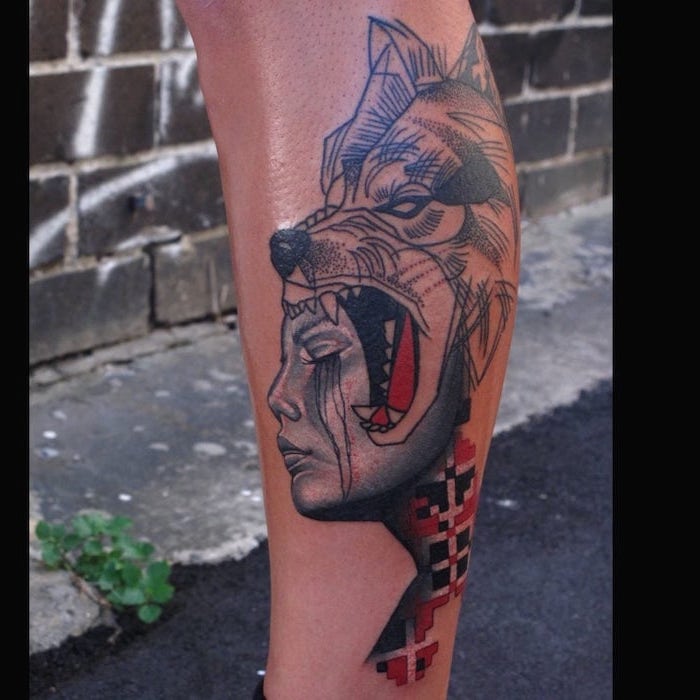 leg tattoo of female face wolf head next to it trash polka design tattooed in red and black