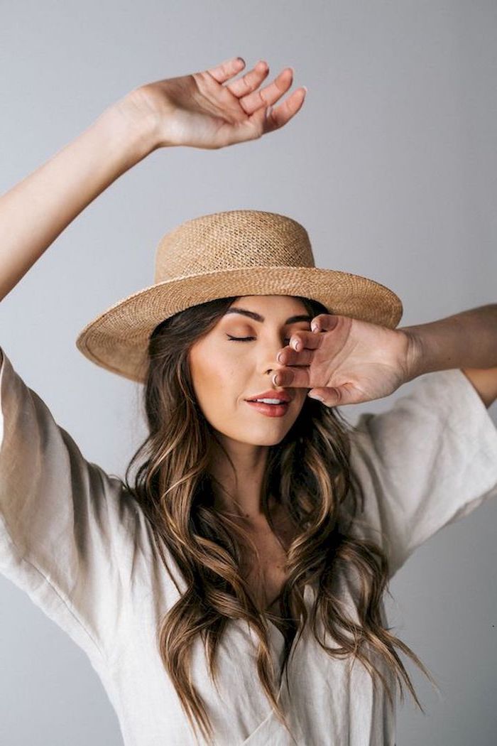 light grey wrap around dress worn by brunette woman cute outfit ideas also wearing hat with long wavy brown hair