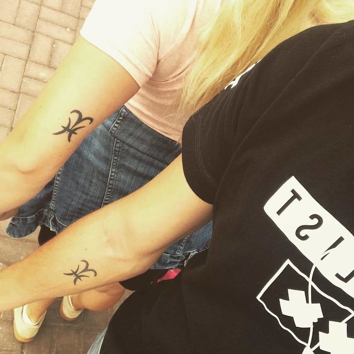 man and woman with matching tattoos of their star signs sibling tattoos for 4 wearing black and white t shirts