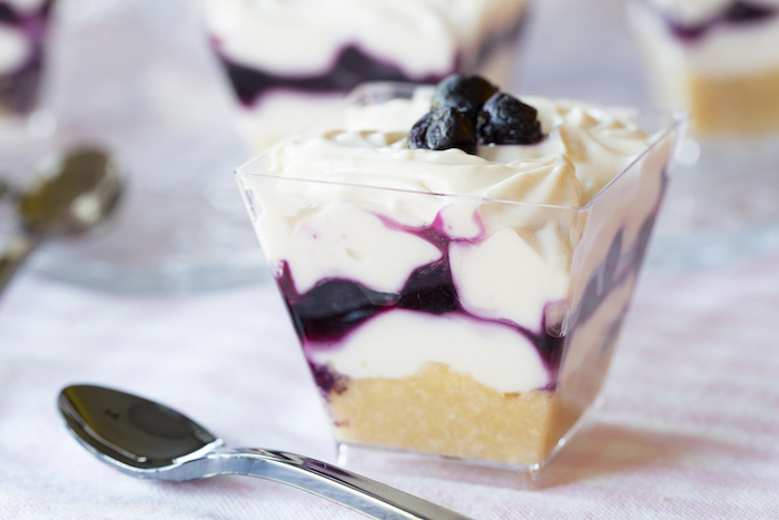mini cheesecake parfaits with blueberries no bake desserts inside small glass bowls spoon on the side