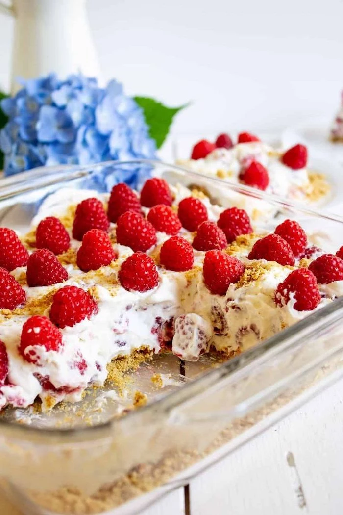 raspberry cheesecake inside glass baking tray summer desserts placed on white wooden surface