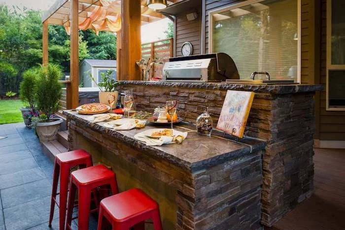 red bar stools next to kitchen island made of stone with granite countertops outdoor bbq ideas built in grill